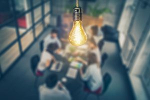 light bulb above creative team brainstorming